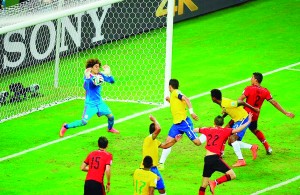 Mexico's goalkeeper Guillermo Ochoa (L) clears the ball shot by Brazil's defender Thiago Silva (C) during a Group A football match between Brazil and Mexico in the Castelao Stadium in Fortaleza during the 2014 FIFA World Cup on June 17, 2014.  AFP PHOTO / FABRICE COFFRINI