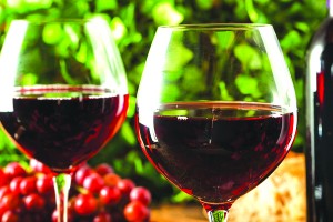 Refreshing Red Wine In a Glass with Grapes