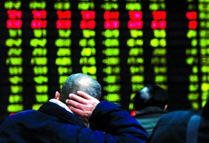 In this photo released by China's Xinhua News Agency, an investor supports his head with a hand while looking at an electric stock price display at a trading hall in a securities firm in Shanghai, China, as the Shanghai Composite Index plummeted 3 percent to 2,325.95 Thursday, Feb. 21, 2013. It was the index's biggest loss in almost 15 months. World stock markets tumbled Thursday after U.S. Federal Reserve minutes gave investors an unwelcome reminder that super-easy monetary policy has an expiration date. (AP Photo/Xinhua, Ding Ding) NO SALES