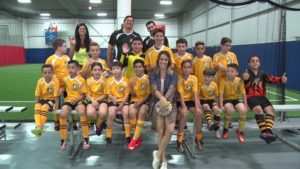 Fernanda Pontes com Alexandre Venturini e o time de futebol.